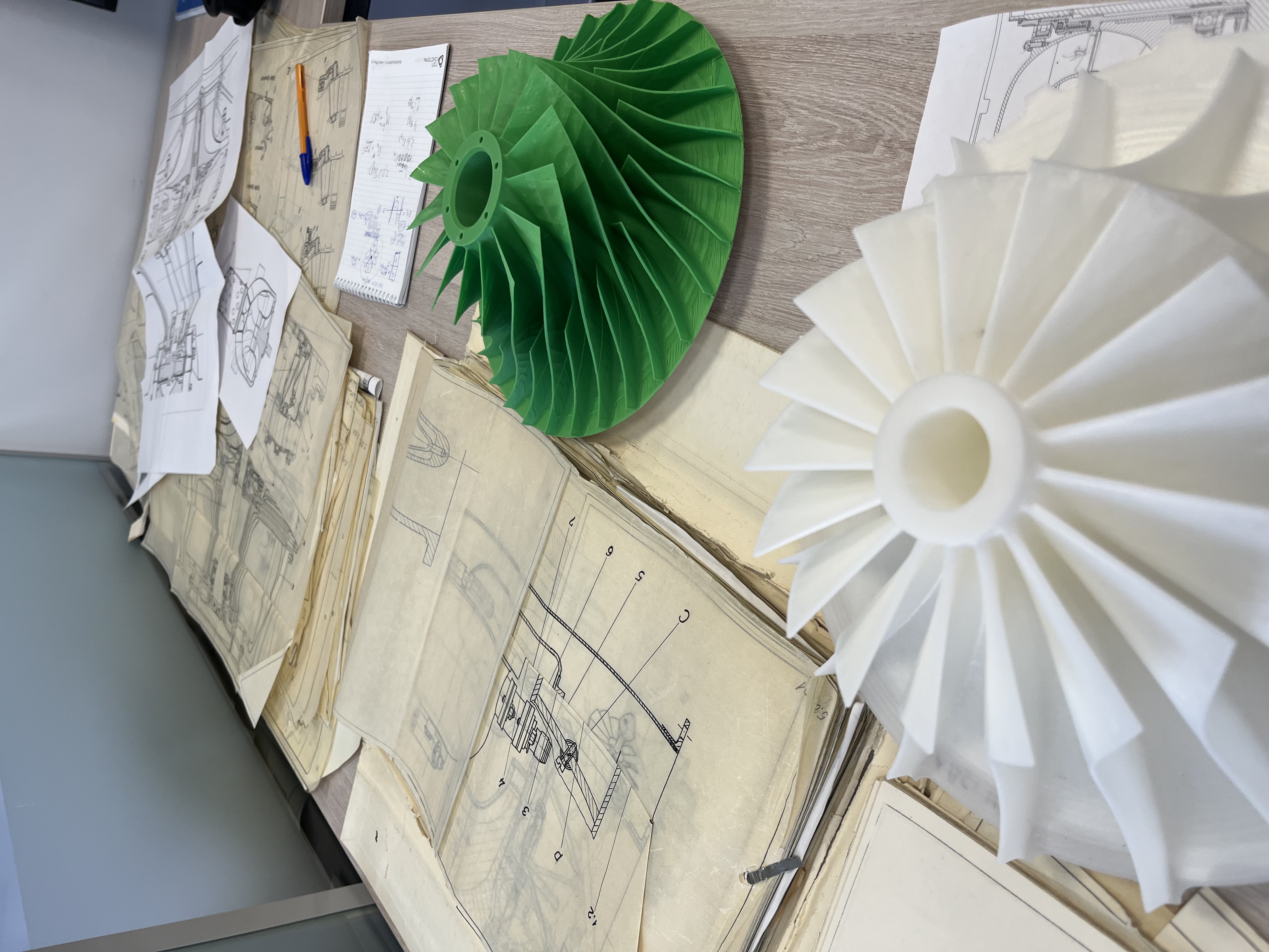 Microturbine 3D-printed prototypes (green and white) alongside Soviet-era turbine engineering documentation preserved by Kostyukov