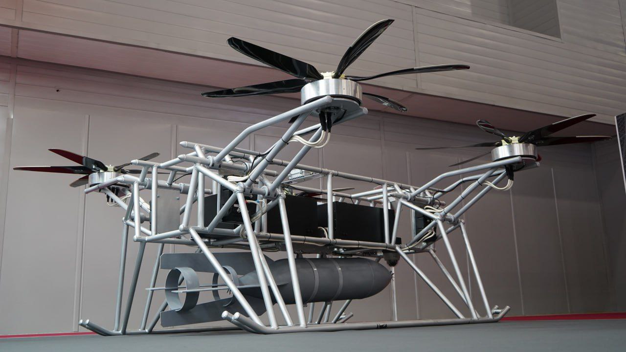 The same demonstrator in a hangar — rotors and payload bay visible